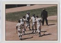 Maris homers on May 24, 1961, and is greeted by Yogi Berra and Johnny Blanchard…